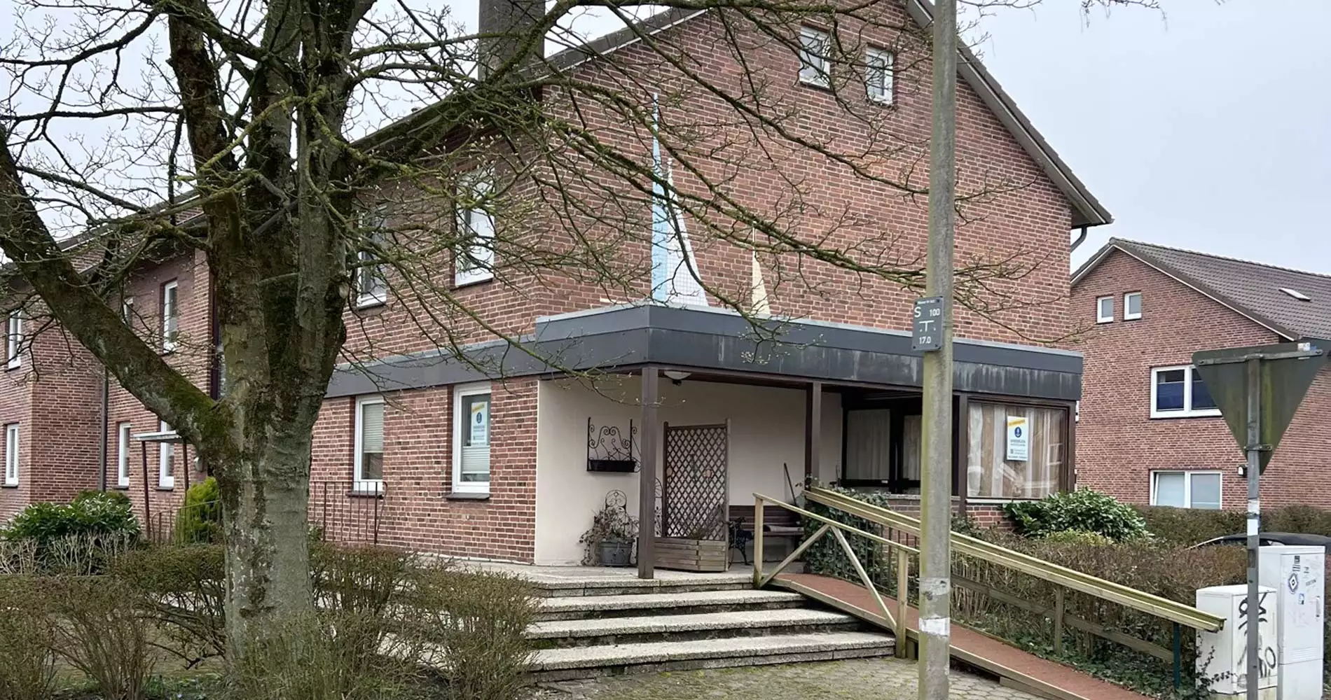 Aussenansicht des Hauses mit der Eigentumswohnung und einem Zugang per kleiner Treppe oder für mobil eingeschränkte Personen