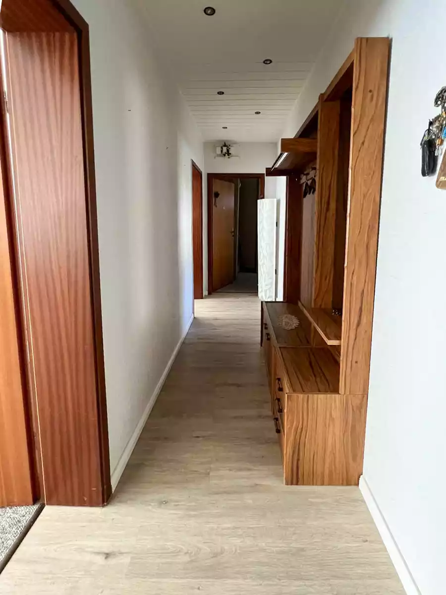 Schmaler Flur mit Laminatboden in Eigentumswohnung in Husum