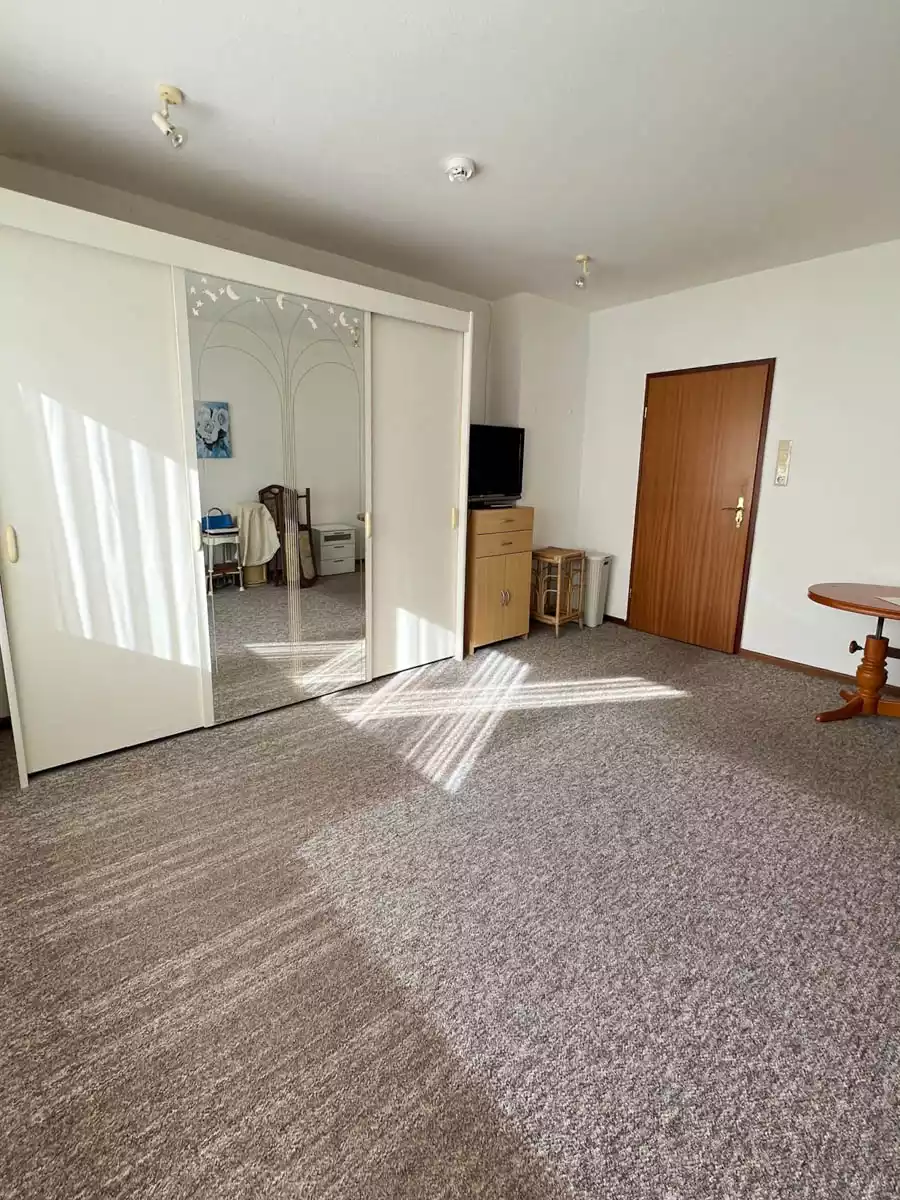 Schlafzimmer mit Teppichboden und Schrank in Eigentumswohnung in Husum