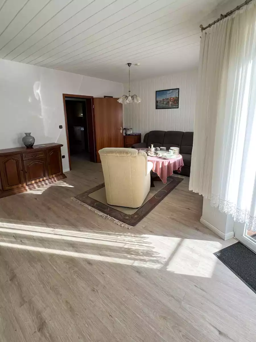 Helles Wohnzimmer mit Laminat und großer Fensterfront in Husum